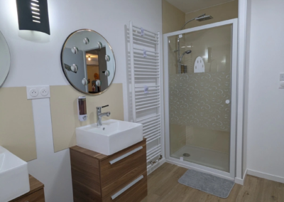 Salle de bains avec douche, lave-linge et double évier